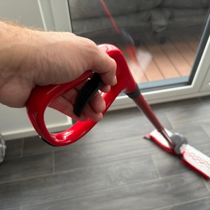 Eine Hand zieht an einem Hebel am Griff vom Vileda Spray & Clean.