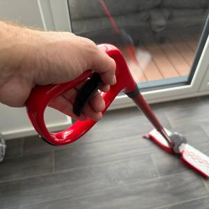 Eine Hand zieht an einem Hebel am Griff vom Vileda Spray & Clean.