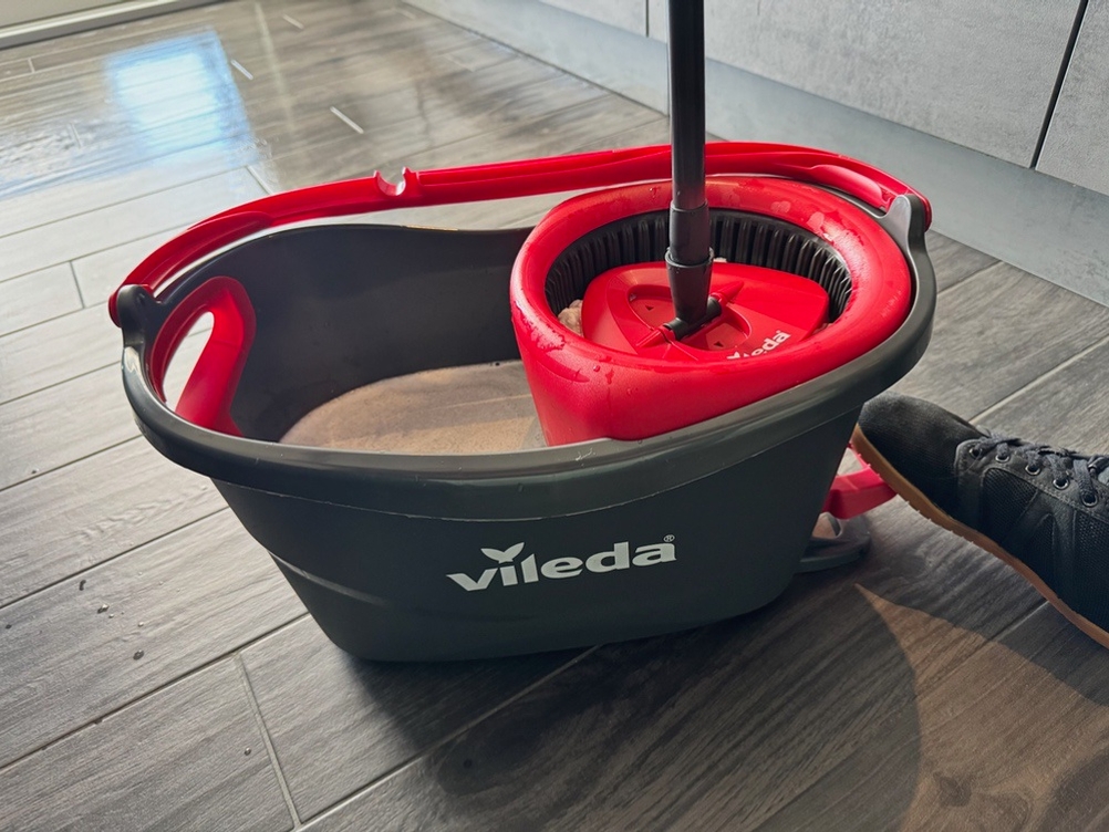 Ein Fuß tritt auf die Schleuder des Vileda-Turbo-Komplett-Bodenwischers.