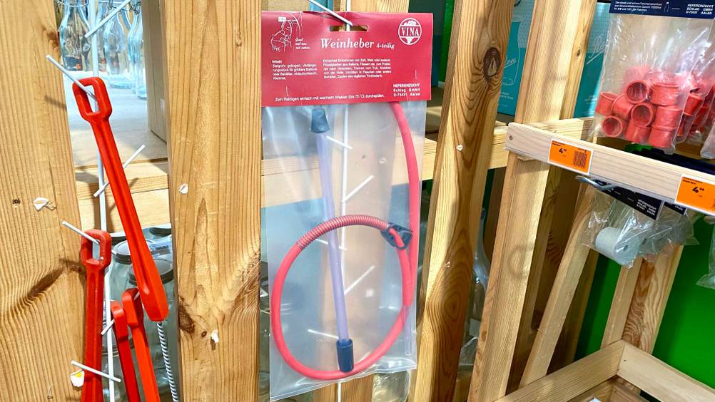 Weinheber-Test: Ein transparent verpackter Weinheber hängt in einem Verkaufsregal neben anderen Produkten.