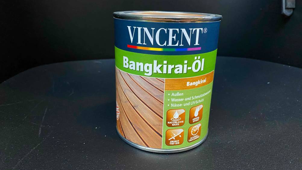 Eine Dose getestetes Bangkirai-Öl auf einer dunklen Fläche.