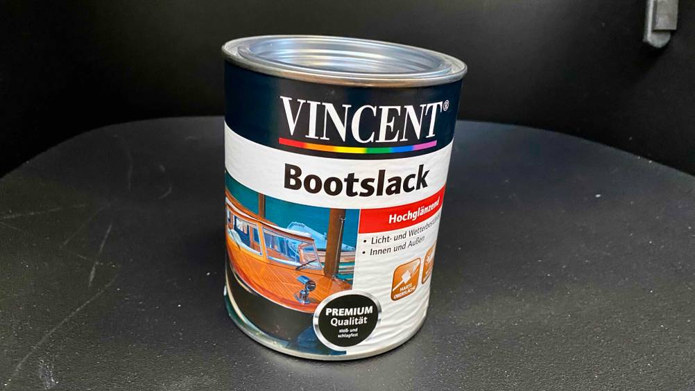 Eine Dose des getesteten Bootslacks von vorne auf einer dunklen Fläche.
