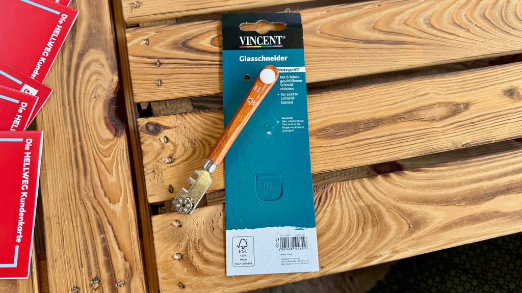 Im Test: Ein Glasschneider liegt auf dem Kartonblister auf einem Holztisch.