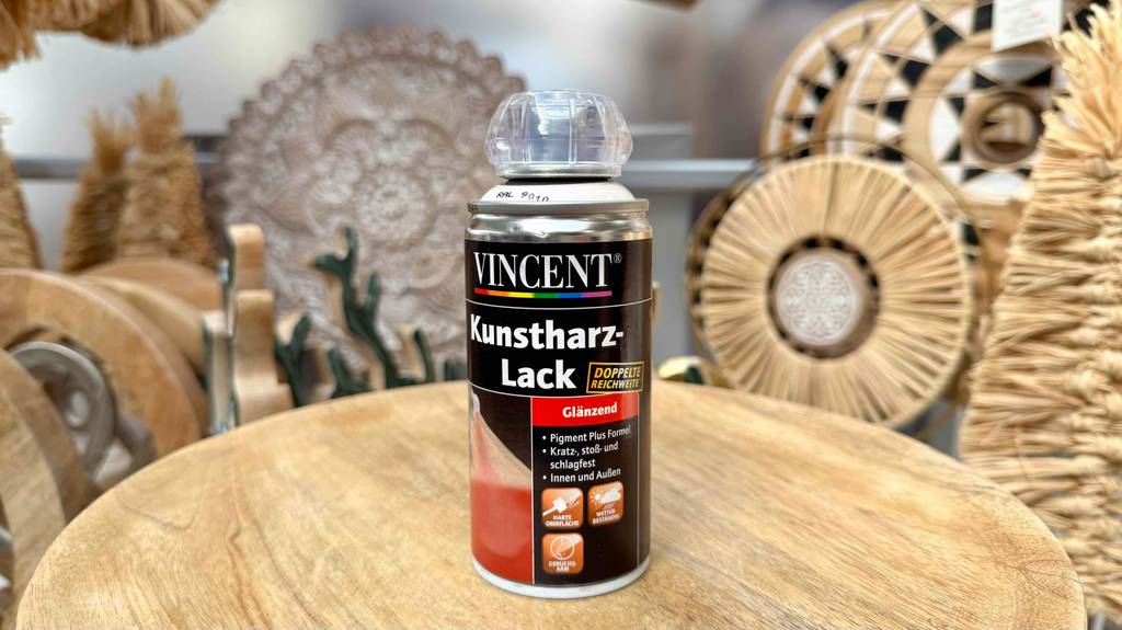 Eine Dose Kunstharzlack steht zum testen auf einer Holzfläche.