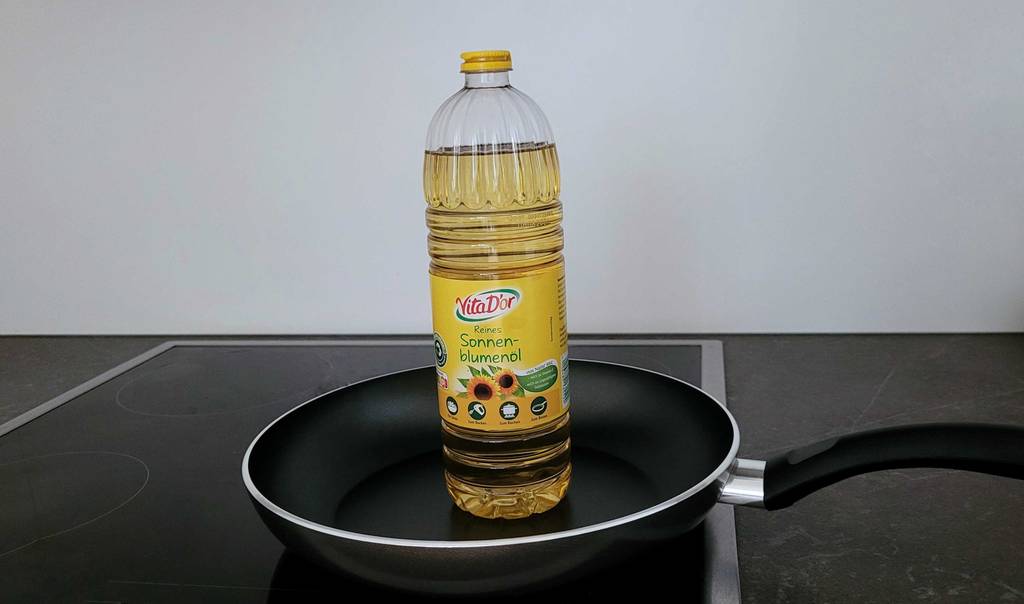 Öl zum braten im Test: Eine Flasche steht in der Mitte einer Bratpfanne.