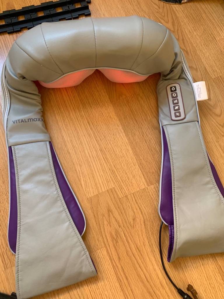 Nahaufnahme von einem beigefarbenen, getesteten Nackenmassagegerät der Marke Vitalmaxx, dessen Infrarot-Massageköpfe eingeschaltet sind.