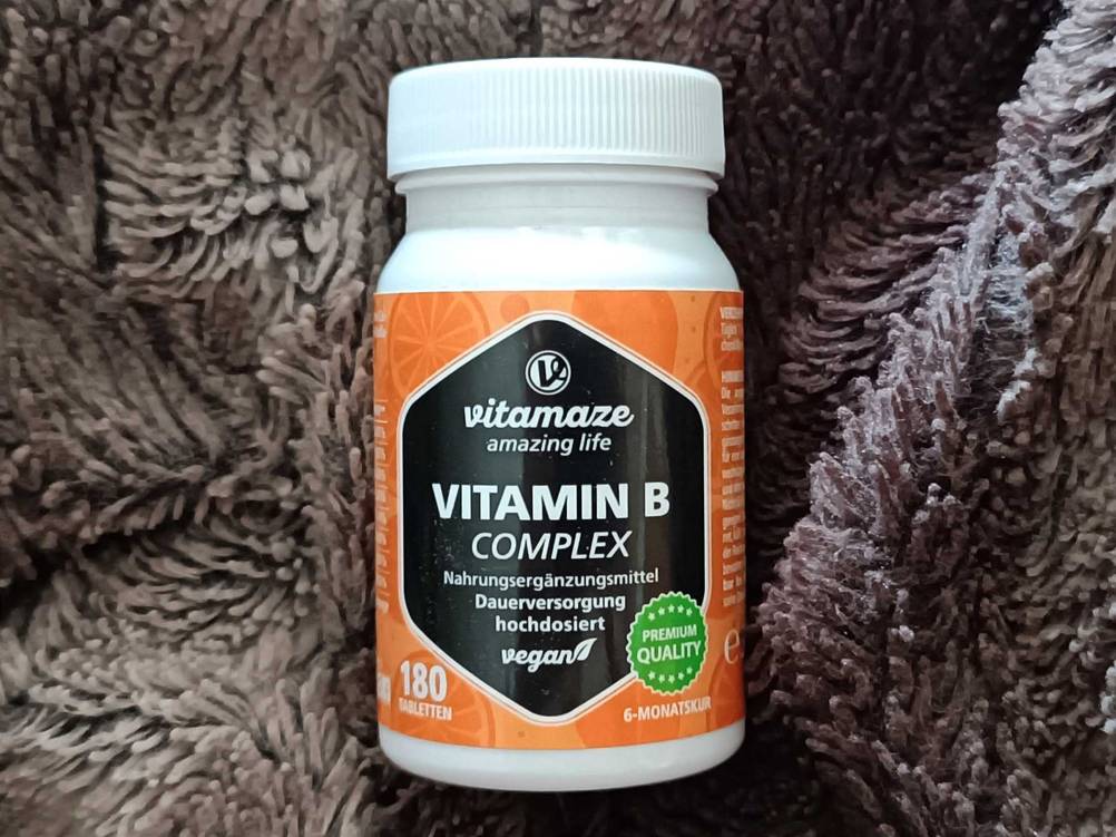 Vitamin-B-Komplex-Fläschchen auf einer Wolldecke