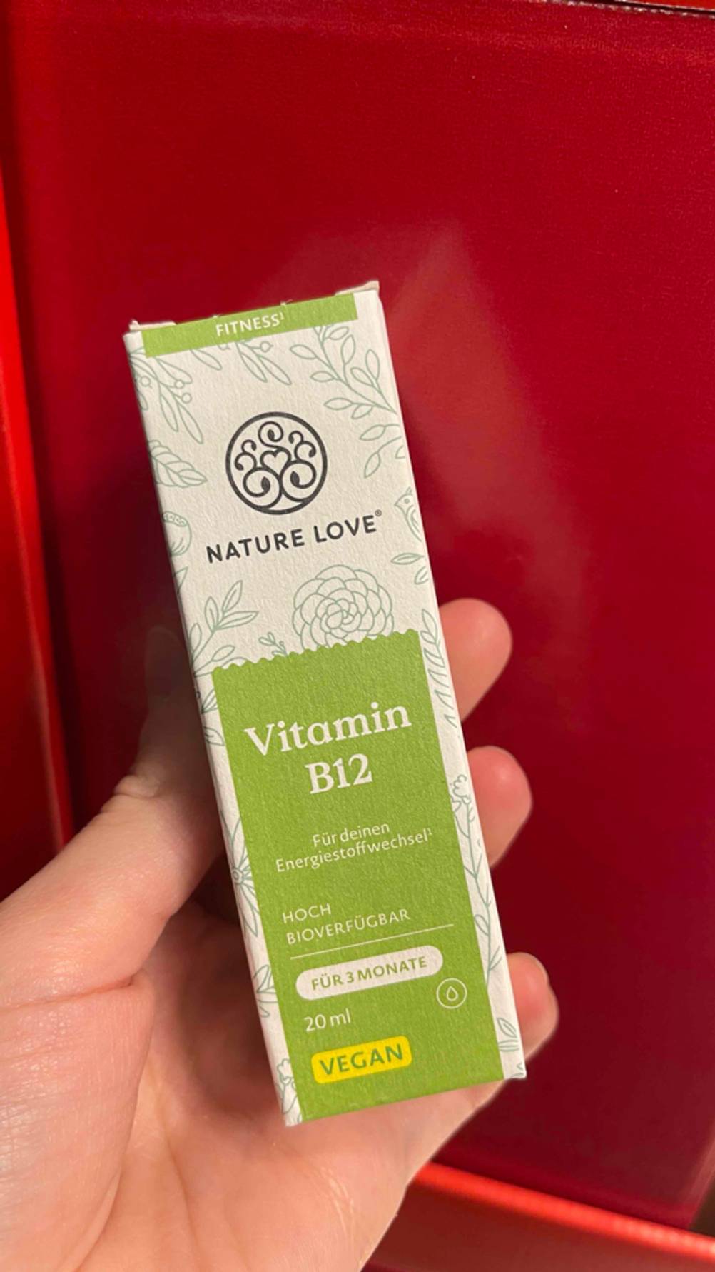 Die getesteten Vitamin-B12-Tropfen vor einer roten Fläche.