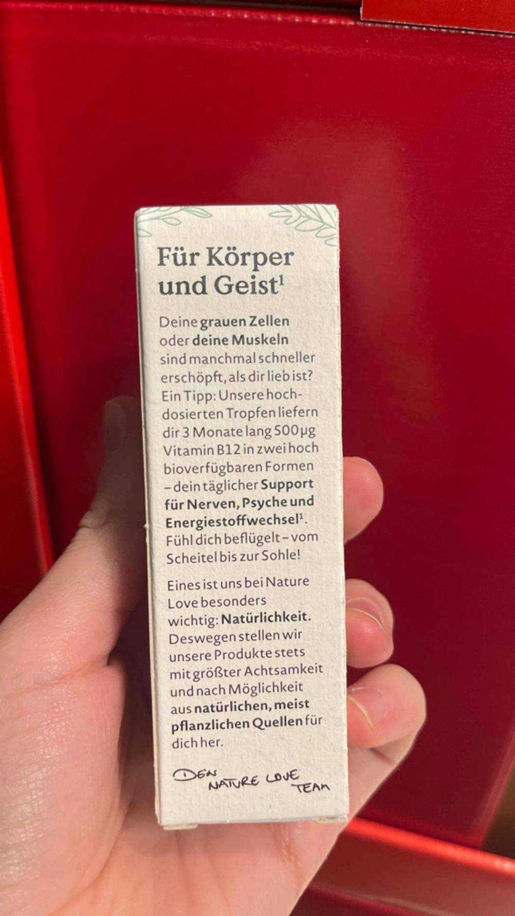 Eine Hand hält die Verpackung der getesteten Vitamin-B12-Tropfen mit Informationen.