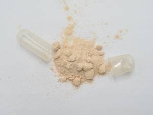 vitamin-c-test: Eine geöffnete Kapsel mit Pulver liegt auf einem Tisch. 
