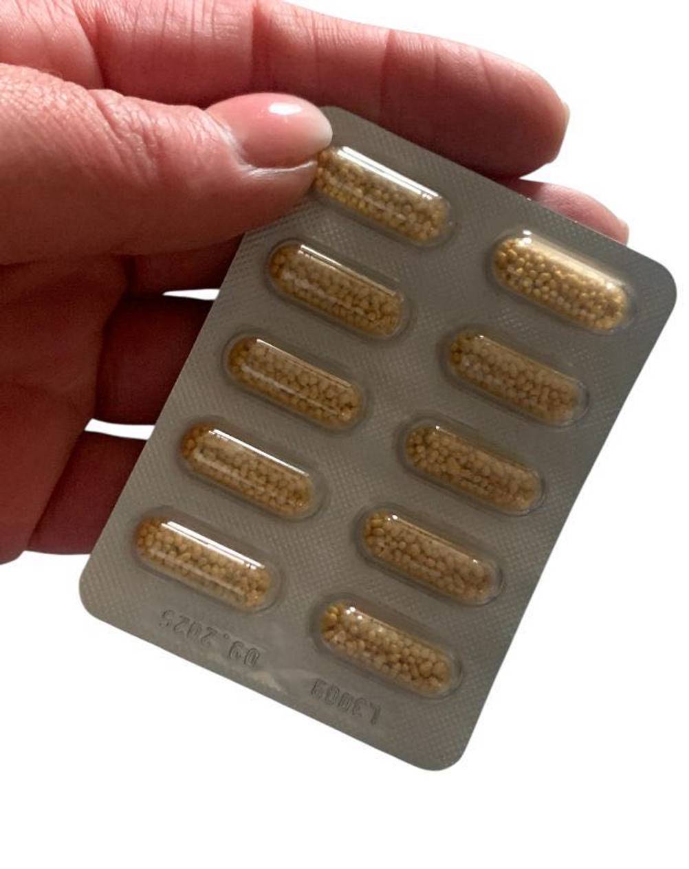 Eine Hand hält eine Tablettenblister der Vitamin-Kapseln im Test.