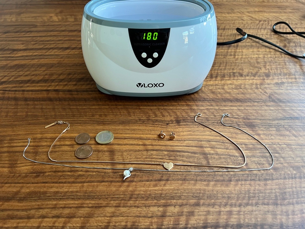 Schmuck, Münzen und Vloxo-K-CSB-006 auf einem Tisch