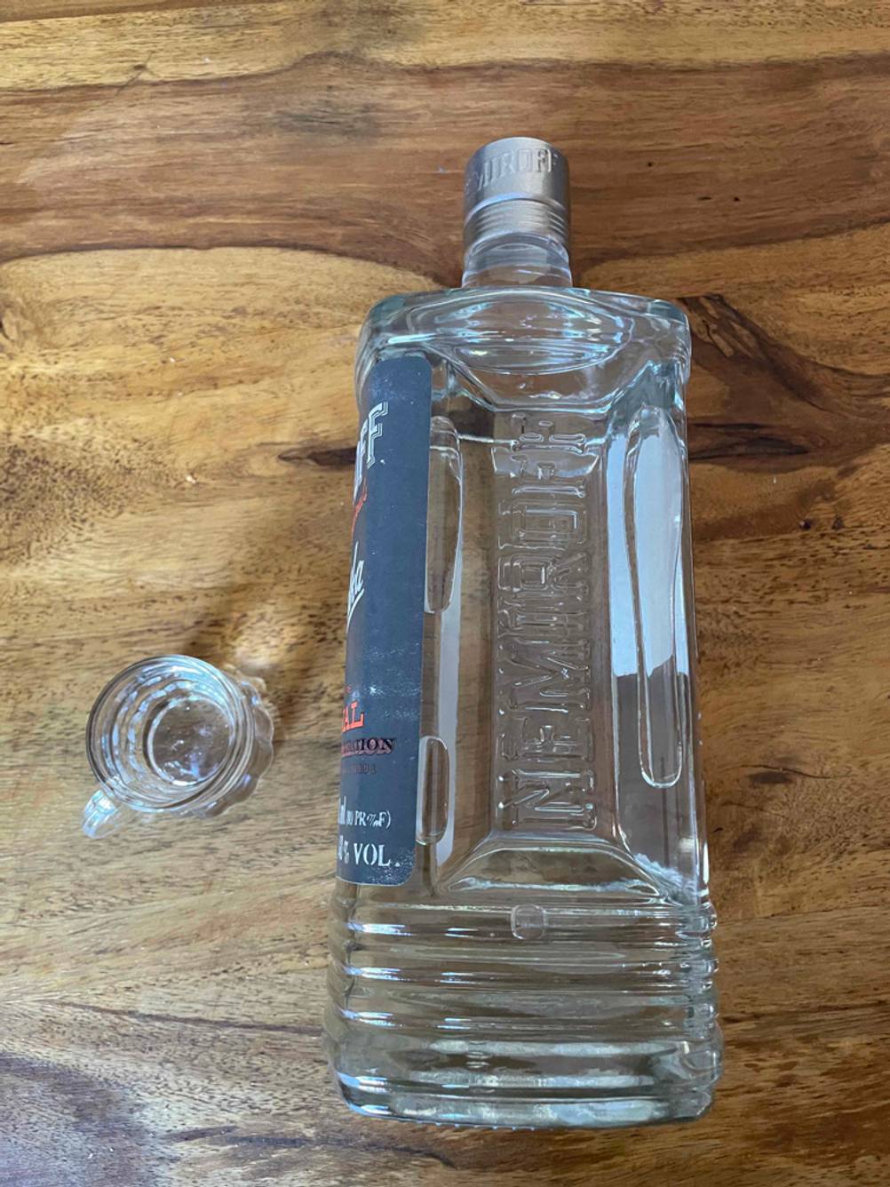 Seitenansicht einer Flasche Vodka im Test auf einem Holztisch liegend.