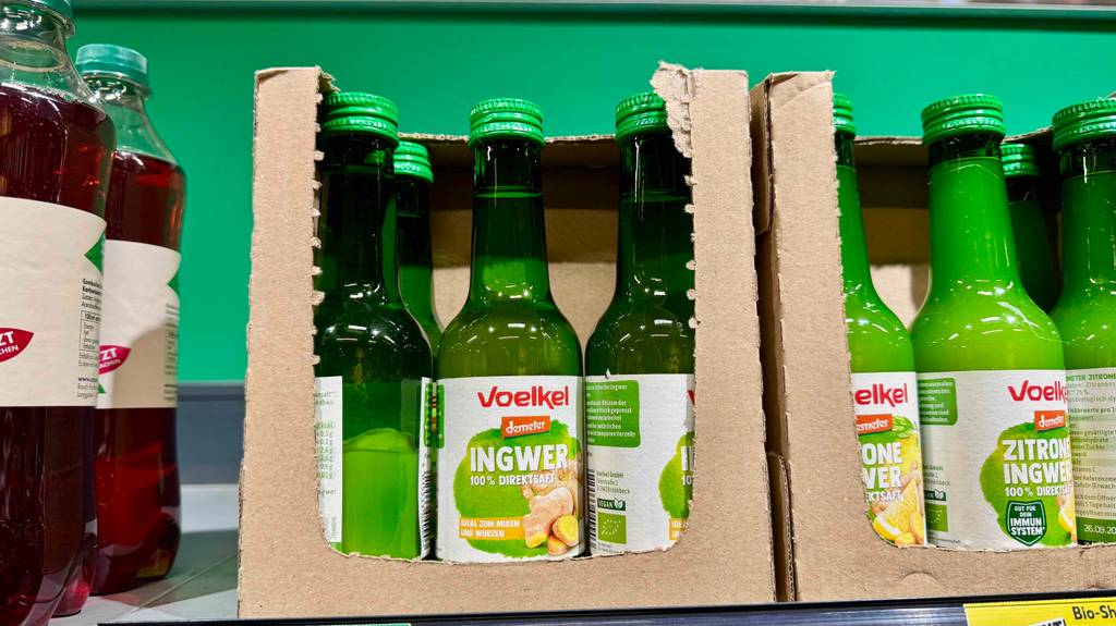 Getesteter Ingwersaft befindet sich in transparenten Glasflaschen auf einem Verkaufsregal.