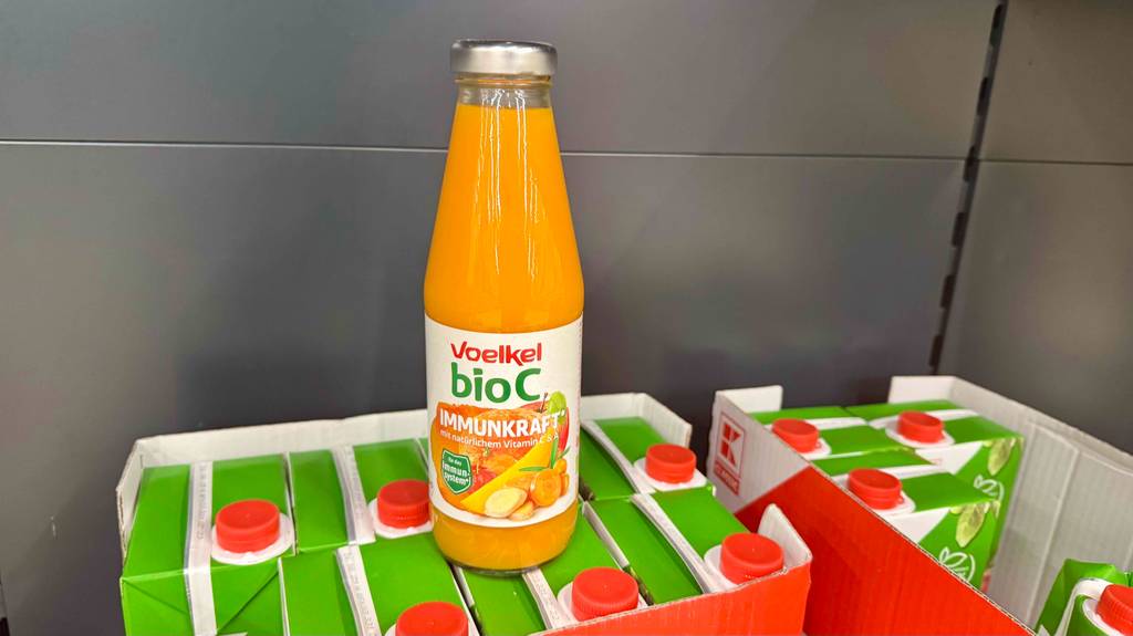 Vitaminsaft im Test: Eine Glasflasche mit Voelkel Bio C Immunkraft steht auf Kartons mit Tetrapaks.