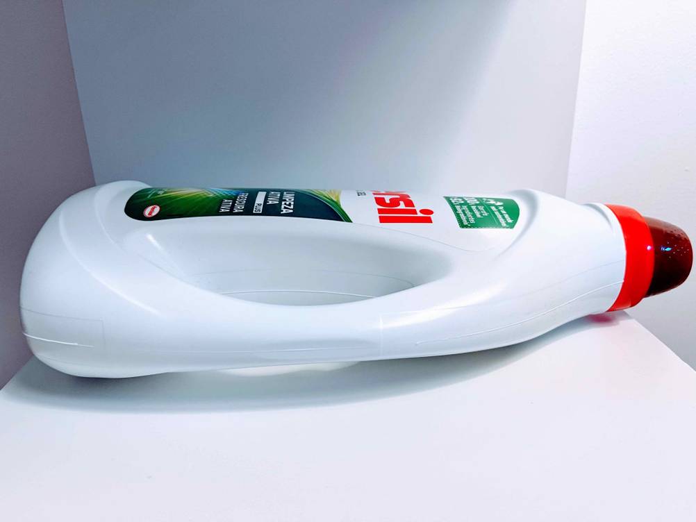 Im Test: Eine liegende Flasche Vollwaschmittel auf einem weißen Regalboden von der Seite.