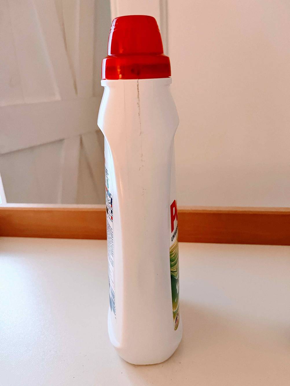 Eine getestete Flasche Vollwaschmittel von der Seite vor einer hellen Wand.