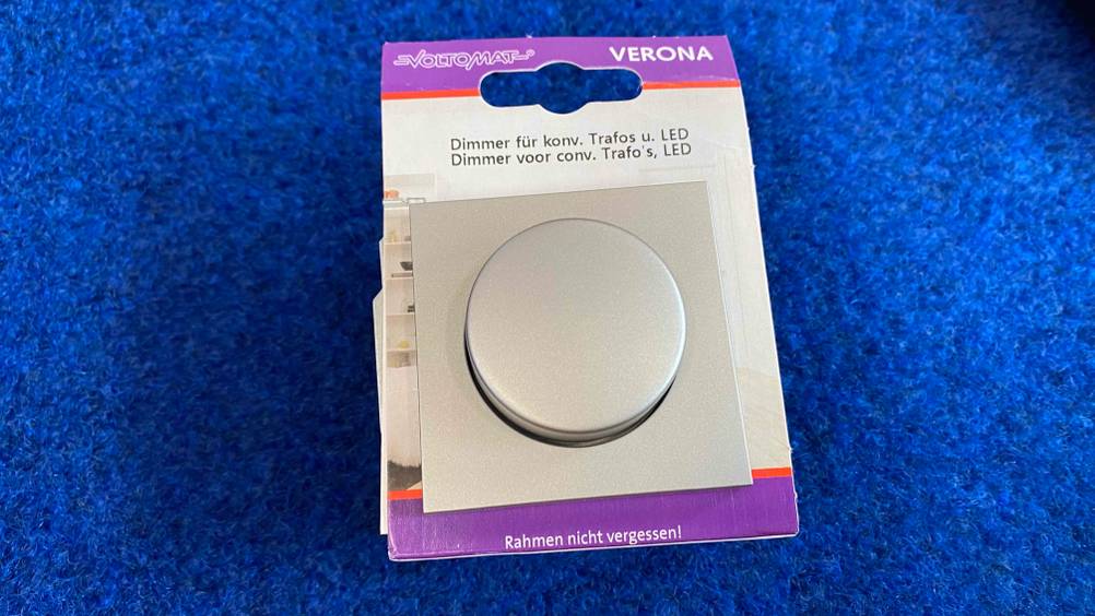 Im Test: Ein originalverpackter Dimmer auf einem blauen Teppich.