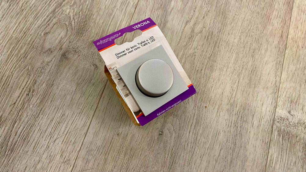 Dimmer-Test: Ein originalverpackter Dimmer im Test auf einem Holzboden.