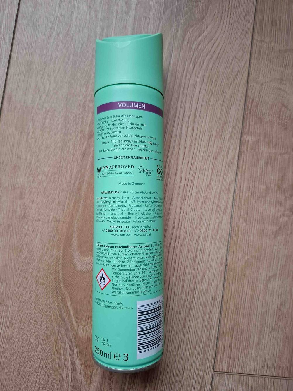 Im Test: Eine Dose Volumen-Spray mit der Rückseite nach oben auf einem Holzboden liegend.