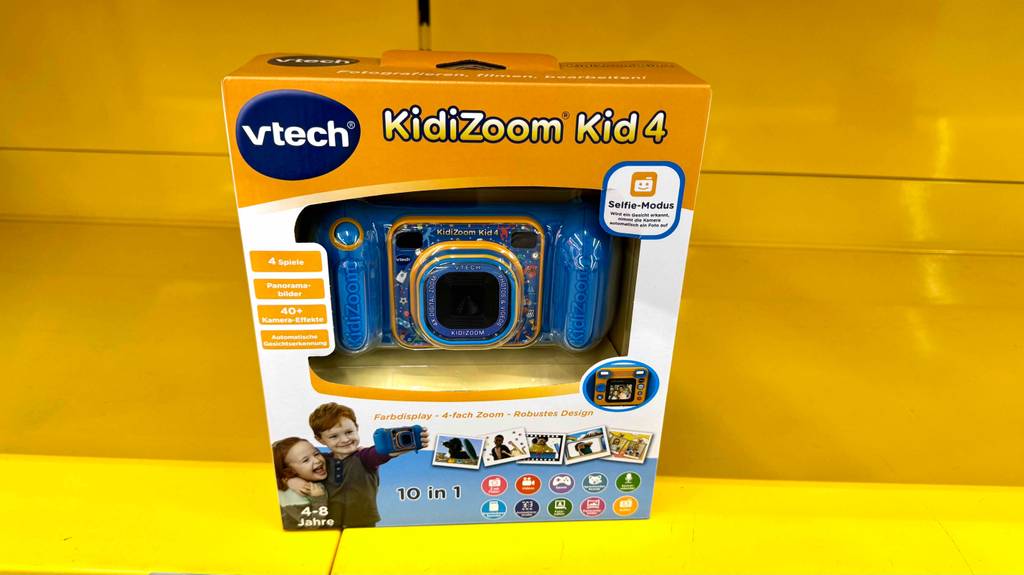 Eine Vtech-Kidizoom steht zum testen in Originalverpackung in einem gelben Regal.