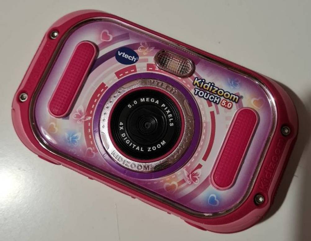 Eine rosa Kinderkamera inklusive farbigen Schmetterlings- und Herzchen-Applikationen.