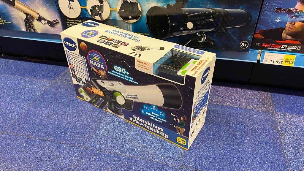 Kinder-Teleskop im Test: Ein Modell von vtech befindet sich in seiner Originalverpackung auf einem blauen Boden vor einem Verkaufsregal.