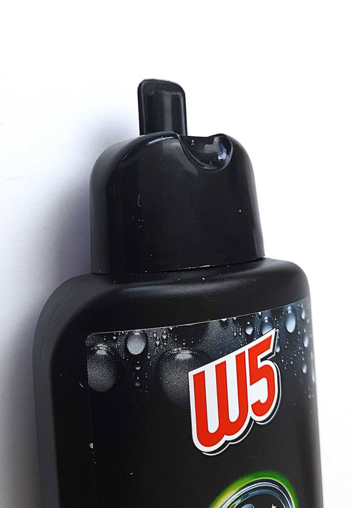 Die schwarze Kunststoffflasche der getesteten Autopolitur steht geöffnet, mit Fokus auf den aufklappbaren Spender vor einer weißen Fläche.