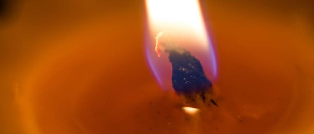Wachsfackel mit Docht im Test: Ein Docht und eine Flamme in Nahaufnahme.