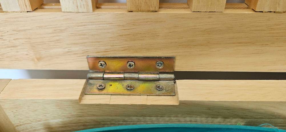 Nahaufnahme des Schaniers einer getesteten Wäschetruhe aus Holz.