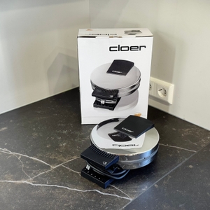 Das getestete Waffeleisen von Cloer steht zusammen mit der Verpackung auf einer dunklen Arbeitsfläche.