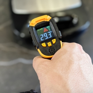 Eine Person misst mit einem Laser-Thermometer die Temperatur des Griffs vom getesteten Waffeleisen von Russell Hobbs.