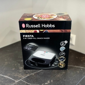 Die Verpackung des getesteten Waffeleisens von Russell Hobbs steht auf einer dunklen Arbeitsfläche.