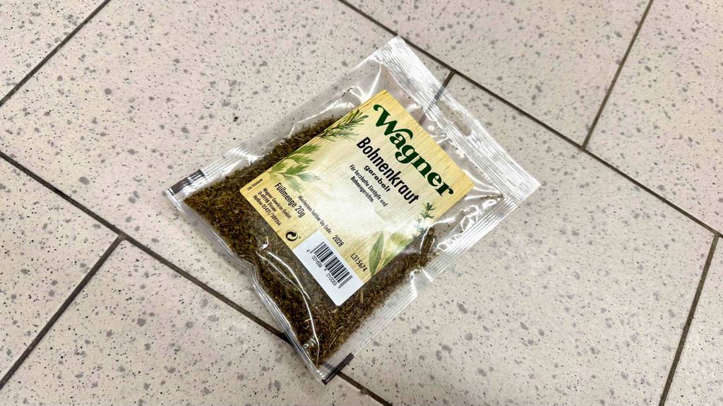 Eine Packung getestetes Bohnenkraut liegt schräg auf einem Fliesenboden.