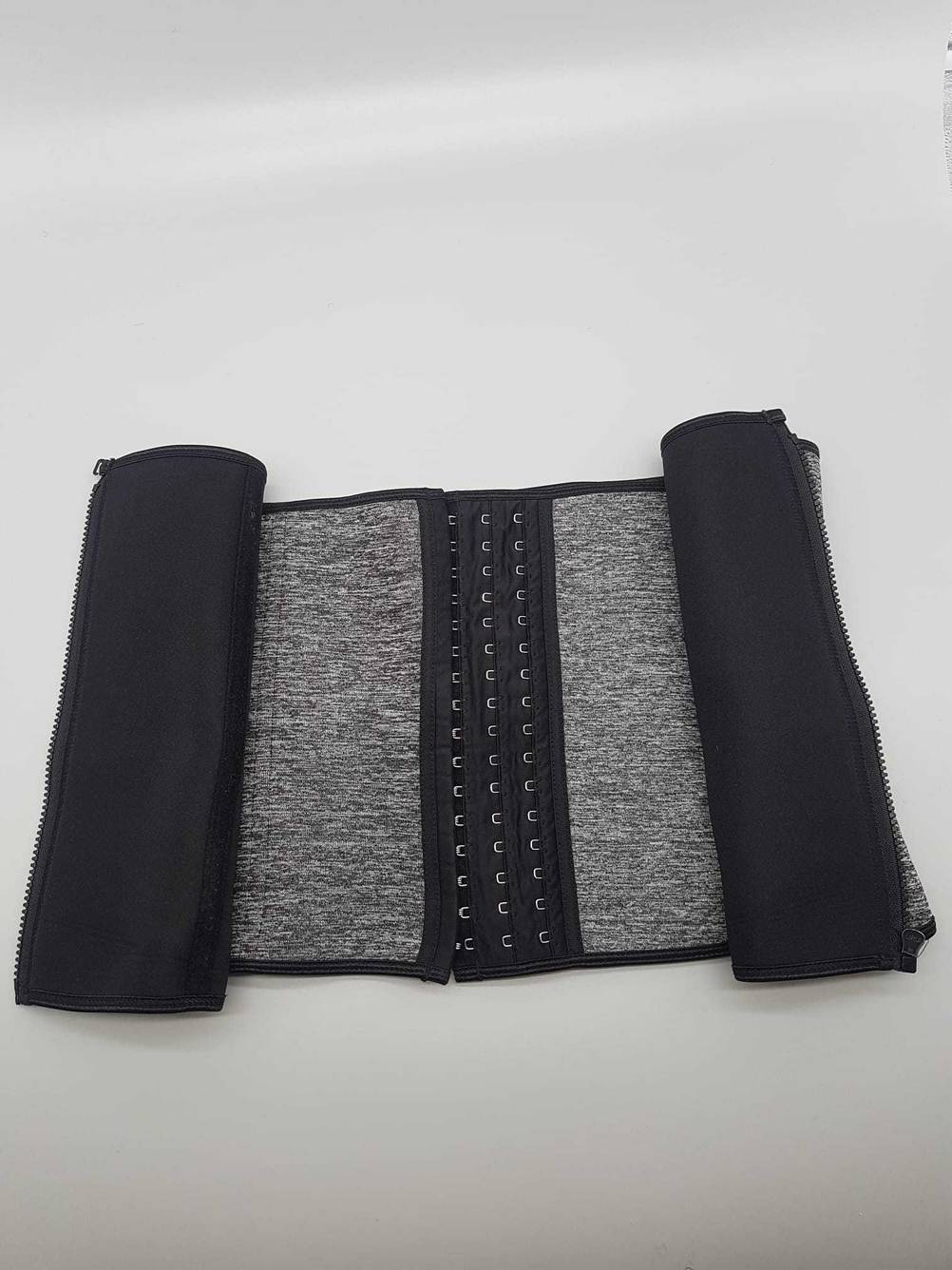 Getestet: Ein Waist-Trainer aufgerollt mit Hackenreihen auf einer hellen Fläche.
