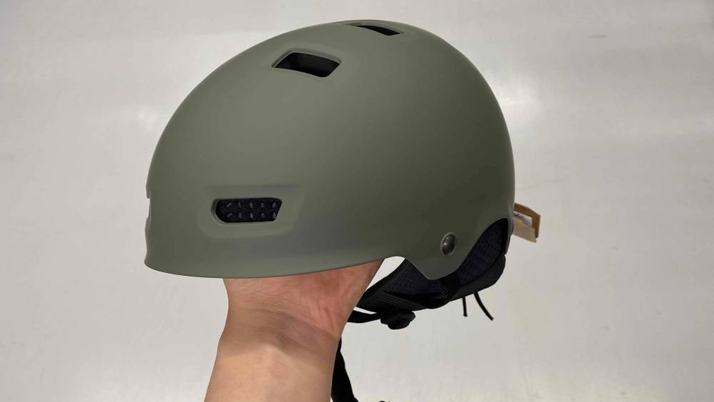 Im Test: Ein Wakeboard-Helm sitzt auf einer Hand vor weißer Wand.