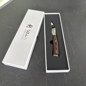Das Wakoli-Edib-Schälmesser liegt in einer Geschenkbox mit offenem Deckel daneben.