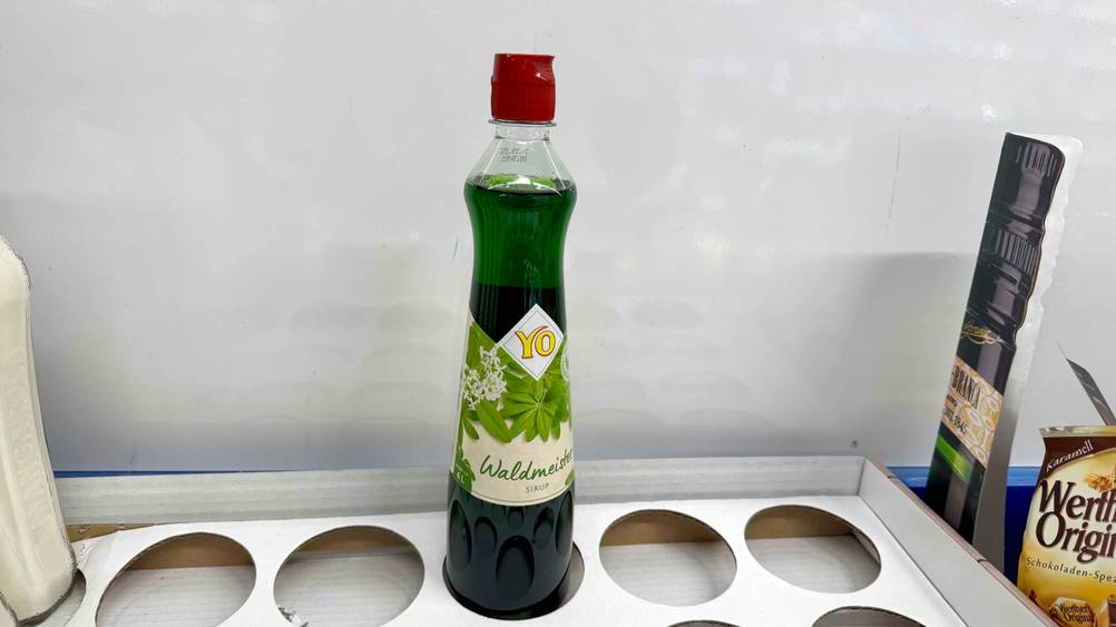 Waldmeistersirup im Test: Eine Flasche in einem Karton stehend.