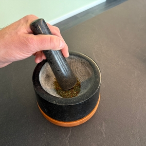 Kräuter liegen im Waldwerk-Mörser.