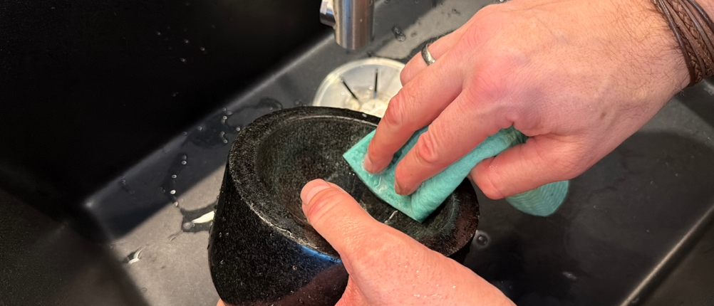 Eine Hand wischt den Waldwerk-Mörser mit einem Lappen ab.