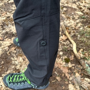 Nahaufnahme der Krempelfunktion der Maier Sports Nil Wanderhose. Der Knopf und die Schlaufe halten das hochgekrempelte Hosenbein sicher fest.