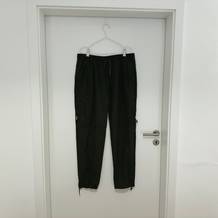 Die Yeyity Wanderhose hängt an einem Bügel an einer weißen Tür.