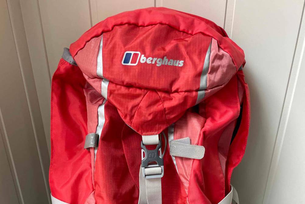 Wanderrucksack-Damen-Test: Ein roter Wanderrucksack von Berghaus steht vor einer weißen Wand. 