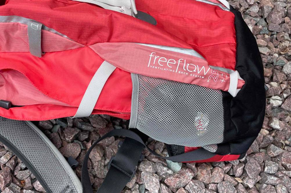 Wanderrucksack-Damen-Test: Ein Berghaus-Freeflow-Wanderrucksack liegt auf Steinen. Zu sehen ist eine Netztasche.