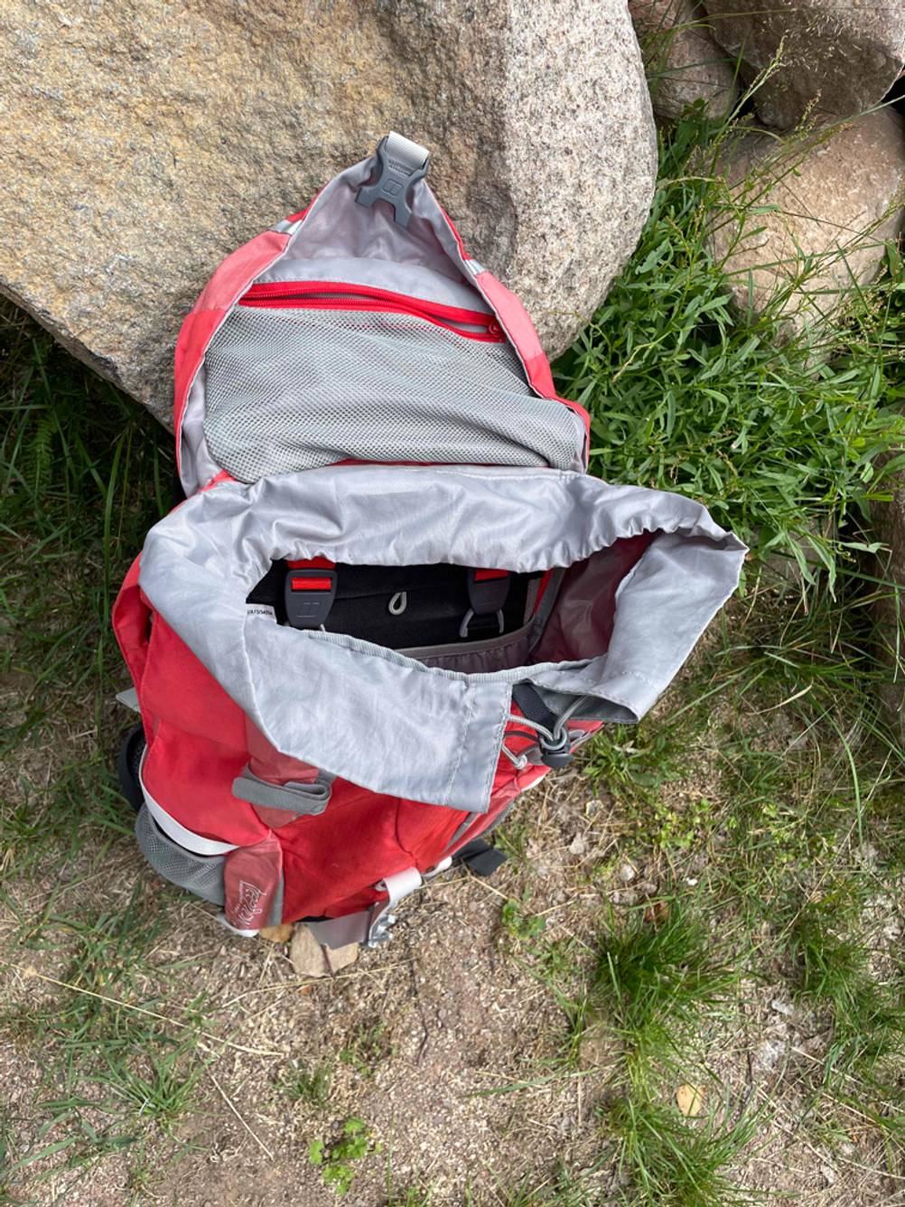 Wanderrucksack für Damen getestet: An einem Stein lehnt ein geöffneter roter Rucksack.
