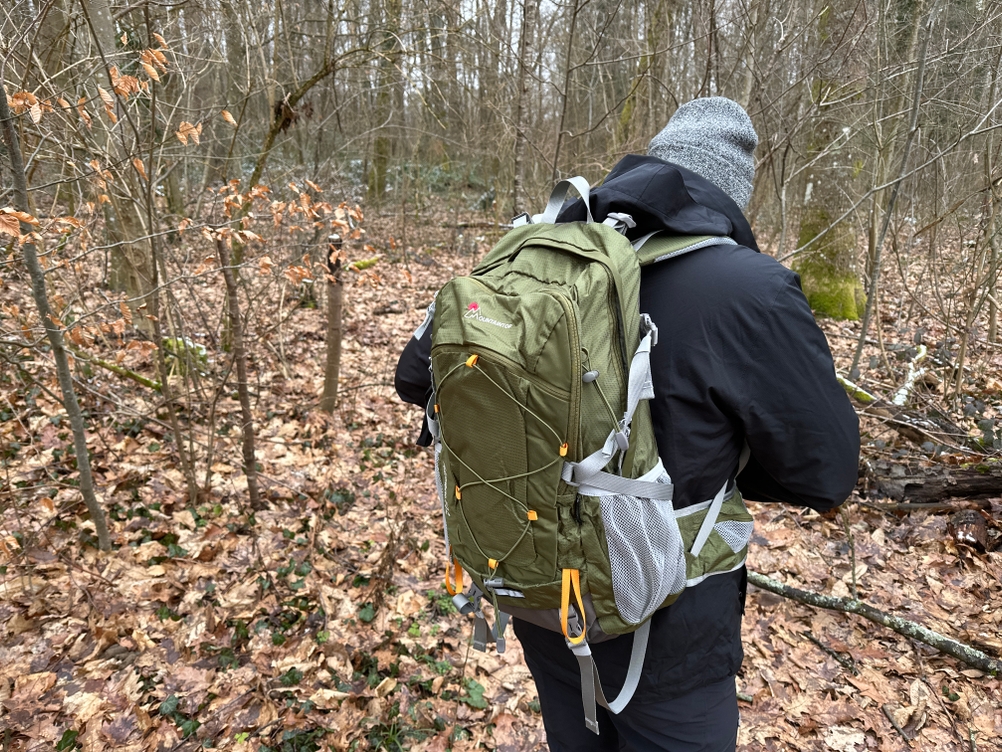 Der Mountaintop-TX5832lanpeicheng-Wanderrucksack im Einsatz auf dem Rücken eines Wanderers im Wald. Der Rucksack wird beim Gehen getragen.
