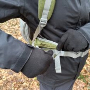 Der Mountaintop-TX5832lanpeicheng-Hüftgurt mit integrierter Reißverschlusstasche. Die Tasche wird mit Handschuhen geöffnet.