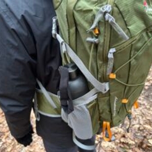 Die seitliche Netztasche des Mountaintop-TX5832lanpeicheng-Wanderrucksacks ist mit einer Trinkflasche befüllt. Die Flasche wird zusätzlich mit einem Riemen gesichert.