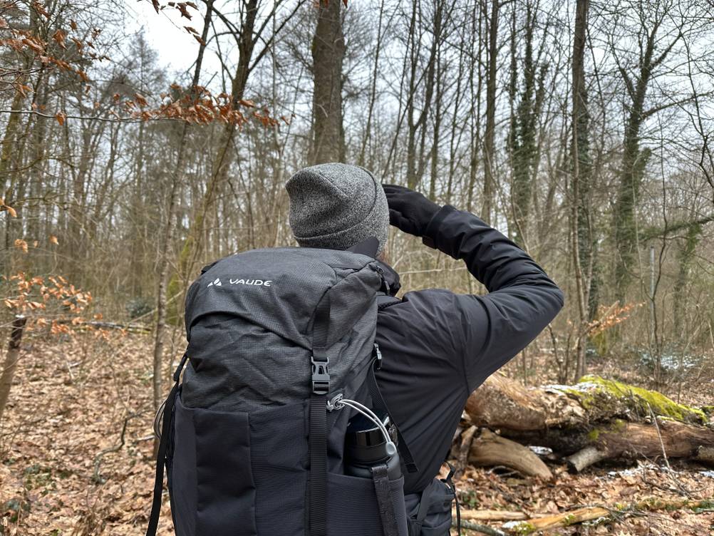Eine Person trägt den Vaude-14394-Wanderrucksack beim Wandern im winterlichen Laubwald. Der Rucksack sitzt eng am Körper.
