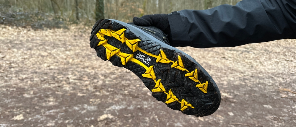 Die Sohle des Jack Wolfskin Vojo 3 Texapore Mid M mit gelben Gummieinsätzen. Das Profil zeigt grobe Stollen für besseren Grip.